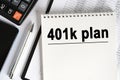 On the table lies a smartphone, a calculator and a notebook with the inscription- 401k plan