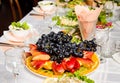 Table lined with variety of dishes from which the centerpiece is dish with sliced fruit Royalty Free Stock Photo