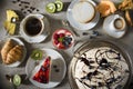 Table with loads of coffee, cakes, cupcakes, cookies, cakepops, desserts, fruits, flowers and croissants. Royalty Free Stock Photo