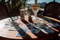 On the table are a lot of different tarot cards and a glass of wine. Selective focus. Generative AI