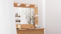 Table with makeup products and mirror near white wall. Dressing room interior Royalty Free Stock Photo