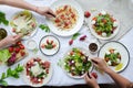 Table with many summer dishes with strawberries. Salads with mozzarella and feta cheese, caprese with buffalo mozzarella and pesto