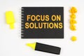 On the table is a marker, an exclamation mark and a notebook with the inscription - FOCUS ON SOLUTIONS