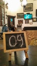 Table number 09 in a room with a vintage interior equipped with wooden chairs, Vespa motorbikes and old bicycles