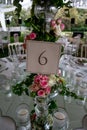Table number stand of a luxury alfresco wedding reception at the countryside; top table flower arrangements, crystal center piece Royalty Free Stock Photo