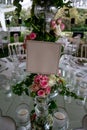 Table number stand of a luxury alfresco wedding reception at the countryside; top table flower arrangements, crystal center pieces Royalty Free Stock Photo