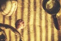 On table, an old map is pinned down with magnifying glass, shells, and rope, and sunlight shines through blinds