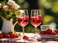 on the table a pair of glasses with strawberry infusion and a vase with roses