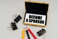 On the table are pencils and a business card holder, inside a business card with the inscription - BECOME A SPONSOR