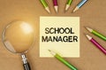 On the table are pencils, a magnifying glass and a sticker with the inscription - School manager Royalty Free Stock Photo