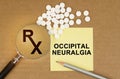 On the table are pills, a magnifying glass, pencils and a sticker with the inscription - Occipital Neuralgia