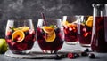 A table with a pitcher and four glasses of red wine with fruit