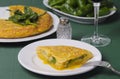 Table with a plate containing a Spanish omelette.