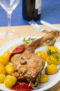 Table with a platter containing a roast leg of lamb. Royalty Free Stock Photo