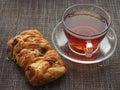 On the table is a puff pastry bun with sweet filling and pecan kernels and a Cup of tea Royalty Free Stock Photo