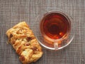 On the table is a puff pastry bun with sweet filling and pecan kernels and a Cup of tea Royalty Free Stock Photo