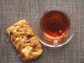 On the table is a puff pastry bun with sweet filling and pecan kernels and a Cup of tea Royalty Free Stock Photo