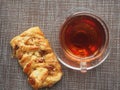 On the table is a puff pastry bun with sweet filling and pecan kernels and a Cup of tea Royalty Free Stock Photo