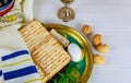 Table ready for traditional seder plate ritual the Jewish holiday of Passover. Kiddush cup, haggada, matzos, lettuce