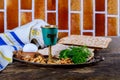 Table ready for traditional seder plate ritual the Jewish holiday of Passover. Kiddush cup, haggada, matzos, lettuce