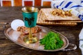 Table ready for traditional seder plate ritual the Jewish holiday of Passover. Kiddush cup, haggada, matzos, lettuce