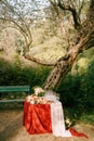 A table with a red cape, served for a wedding event with empty clean docks for champagne and a bouquet of flowers under