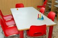Table with red chairs of a school class for children