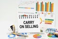 On the table are reports with graphs and a notepad with the inscription - Carry on Selling