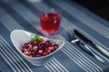Table in the restaurant. On the table is a salad in a white plate, a knife, a fork, a glass with red juice. On the table Royalty Free Stock Photo