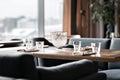 Table in restaurant served for lunch. Glasses, flower fork, knife served for dinner in restaurant with cozy interior Royalty Free Stock Photo