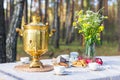 Table with russian samovar, cups decorated with some flowers