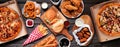 Table scene of assorted take out or delivery foods, top down view on a dark wood banner Royalty Free Stock Photo