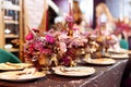 Table served for Christmas dinner, festive setting with decorations, burning candles and golden fern branches, glasses. Selected Royalty Free Stock Photo