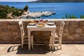 A table served for two with chicken souvlaki and french fries, greek salad, snacks and drinks on the summer terrace of the hotel r Royalty Free Stock Photo