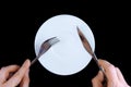 Table serving-knife, fork in hands Royalty Free Stock Photo