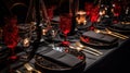 a table set with a black table cloth and gold place settings