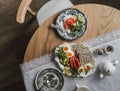 A table set for breakfast, brunch - a plate with bread, smoked salmon, avocado, boiled eggs on a round wooden table, top view