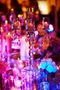 Table set with candles for a festive event, party or wedding reception, in purple light Royalty Free Stock Photo