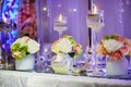 Table set with candles and flowers for a festive event, party or wedding reception Royalty Free Stock Photo