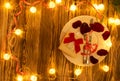 Table set for celebration Valentine`s Day. Wooden place setting with red heart and glittering lights .
