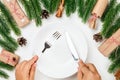 table set for Christmas party. Female hands hold a silver knife and fork over white empty plate Royalty Free Stock Photo