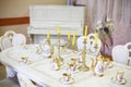 Table with set of porcelain dishes and candles and