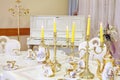 Table with set of porcelain dishes and candles in