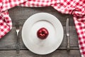 Table set with red apple on white plate with knife and fork with red checkered napkin. Royalty Free Stock Photo