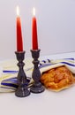 table set for Shabbat with lighted candles, challah bread and wine. Royalty Free Stock Photo