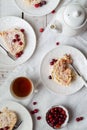 Table set for tea with meringue roulade, fresh cranberries, tea cups on Nordic style background, top view Royalty Free Stock Photo