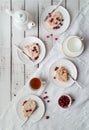 Table set for tea with meringue roulade, fresh cranberries, tea cups on Nordic style wooden background Royalty Free Stock Photo