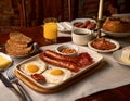 A table set for a traditional Irish breakfast, featuring sausages, bacon, eggs, and soda bread Royalty Free Stock Photo