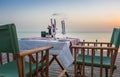 Table set for two on sea coast. Romantic table setting on the sunset. Outdoor restaurant on the beach. Elegant cafe decoration. Royalty Free Stock Photo