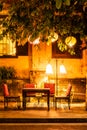 Outdoor seating at a restaurant with orange glow of street lights Royalty Free Stock Photo